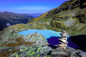 Piled stones in front of mountain lake